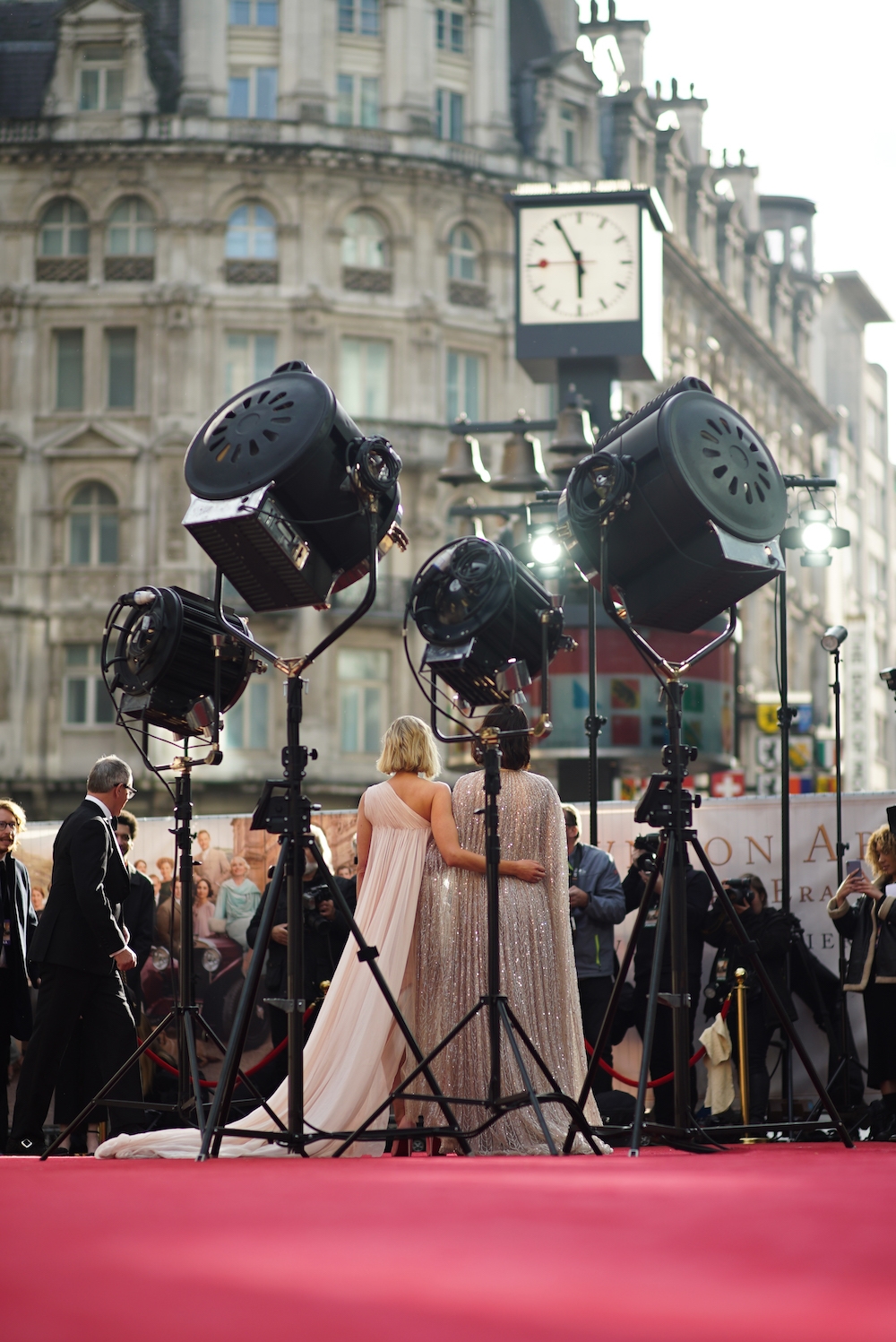 actor standing on the red carpet surrounded by lights